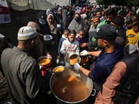 Displaced Palestinians are receiving food at a donation point in Deir al-Balah, central Gaza Strip, on February 24, 2024, amid continuing ba...