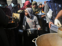 Displaced Palestinians are gathering to receive food at a donation point in Deir al-Balah, central Gaza Strip, on February 24, 2024, amid co...