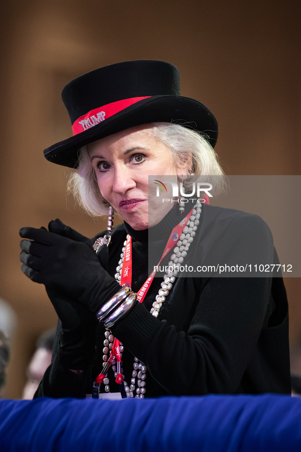 A woman in Trump-inspired attire applauds Steve Bannon at the annual Conservative Political Action Conference (CPAC) in National Harbor, MD,...