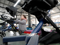 A worker is assembling a stroller on a production line at a stroller manufacturing company in Handan, Hebei Province, China, on February 29,...