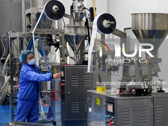 Employees are working on a processing line of multi-grain instant food products at a biotech company in Zhangjiakou, China, on March 3, 2024...