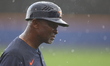 Houston Astros third base coach Gary Pettis is watching the action as rain falls during th...