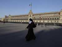 A nun is walking in front of the National Palace in Mexico City, which is protected with metal fences prior to protests on the occasion of I...