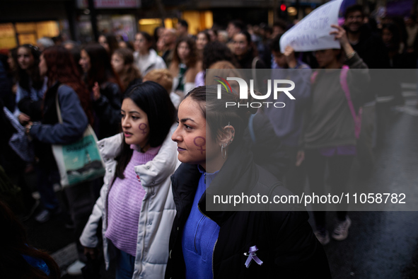 Two women, each with a female symbol on their face, are participating in the International Women's Day demonstration in Granada, Spain, on M...