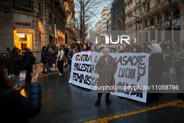 A woman is taking a photo in front of one of the banners at the International Women's Day demonstration in Granada, Spain, on March 8, 2024....
