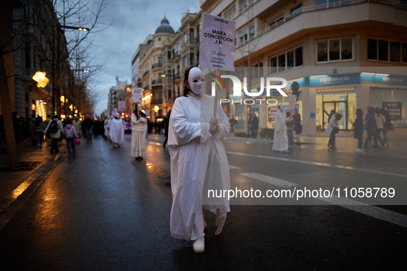 A woman is wearing a mask that symbolizes a murdered woman before the International Women's Day demonstration in Granada, Spain, on March 8,...