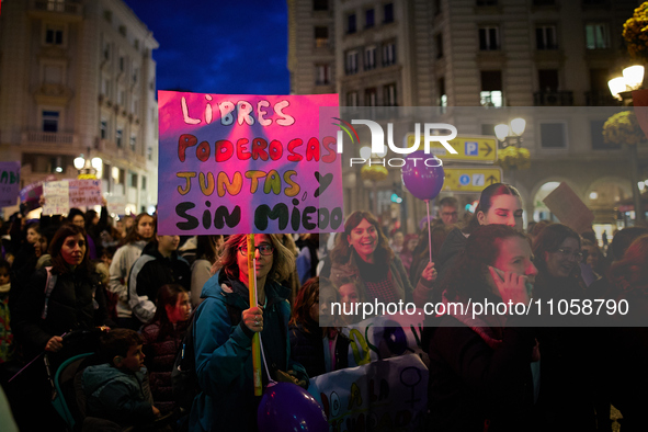 A protester is holding a banner that reads ''Free, powerful, together and without fear'' during the International Women's Day demonstration...