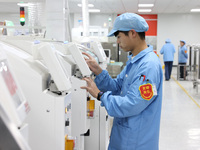 A staff member is producing digital network products in a production workshop of a technology enterprise in Fuzhou, China, on March 14, 2024...