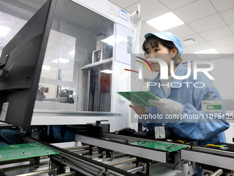 A staff member is producing digital network products in a production workshop of a technology enterprise in Fuzhou, China, on March 14, 2024...