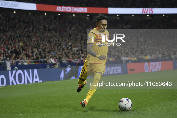 Raphinha is running with the ball during the La Liga soccer match between Atletico Madrid and Barcelona at the Metropolitano stadium in Madr...