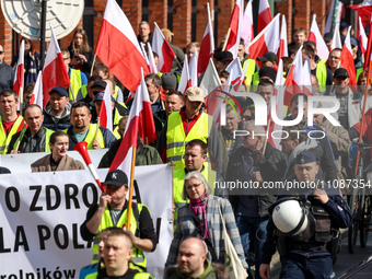 Polish farmers and their supporters walk with Polish flags  and banners during a protest on Lubicz Street in the centre of Krakow, the capit...