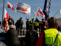 Polish farmers and their supporters hold Polish and Solidarnosc (Solidarity) Union flags and banners during a protest on Mogilskie roundabou...