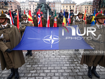 Soldiers of the Polish army hold NATO flag while taking part in official celebration of the 25th anniversary of Poland's accession to the st...