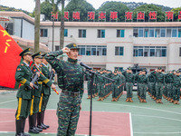 Newly joined SWAT team members are lining up and taking an oath under the military flag and the flag of the special operators during the ind...