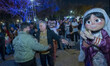 Two Iranian men are dancing in a park in downtown Tehran while a street artist, dressed as...