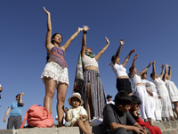 A woman is raising her hands to fill herself with energy during the spring equinox in the archaeological zone of Teotihuacan in the Municipa...
