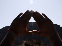 A woman is raising her hands to fill herself with energy during the spring equinox in the archaeological zone of Teotihuacan in the Municipa...