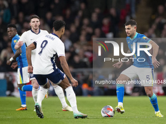 Bruno Guimaraes #5 of Brazil is being tackled by Ollie Watkins of England during the International Friendly match between England and Brazil...