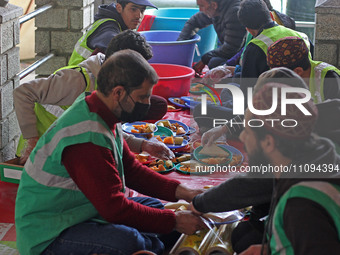 Volunteers are packing 'iftar' meals during the ongoing holy month of Ramadan outside Bilal Masjid in the heart of Srinagar, Kashmir, India,...