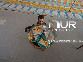 A volunteer is carrying 'iftar' meals before distributing them outside Bilal Masjid, located in the heart of the city in Srinagar, Kashmir,...
