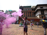 Children are setting off colored smoke while celebrating Holi, the festival of colors, at Kathmandu Durbar Square, a UNESCO World Heritage S...