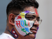 A Nepali reveler is painting his cheek with wishes for Holi, the festival of colors, in Kathmandu Durbar Square, a UNESCO World Heritage Sit...
