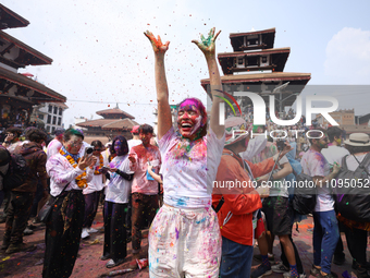 A foreign national is dancing to the beats of traditional Nepali musical instruments as she participates in celebrating Holi, the festival o...