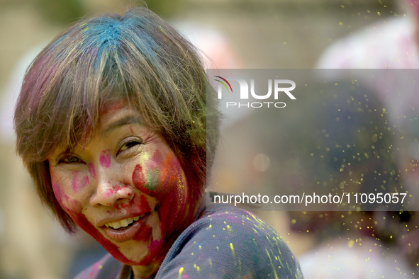 A foreign national is gesturing as she participates in the mass celebration of the festival of Holi, the festival of colors, at Kathmandu Du...