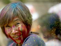 A foreign national is gesturing as she participates in the mass celebration of the festival of Holi, the festival of colors, at Kathmandu Du...
