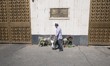 An Iranian man is walking past flowers placed outside the Russian embassy to honor the vic...