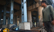 A worker is welding iron rods at the repair site of a bridge in Kolkata, India, on March 2...