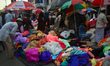A person is selling colorful pieces of cloth for the upcoming Eid al-Fitr festival at a ma...