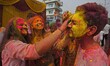 People are playing with colors during Holi celebrations in Nagaon district, Assam, India,...