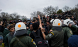 Macedonian policemen scuffle with stranded migrants at the Greek-Macedonian border, near t...