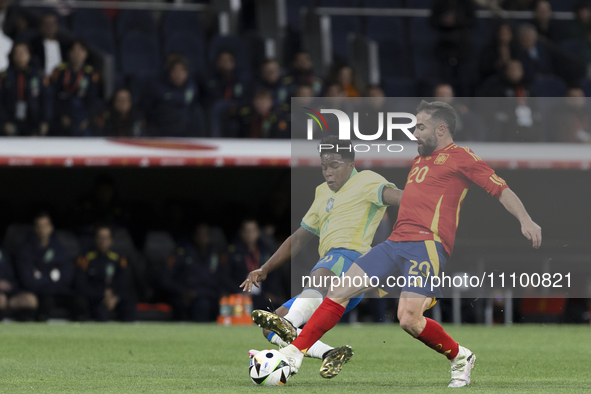 Endrick of Brazil and Daniel Carvajal of Spain are in action during the friendly match between Spain and Brazil at Santiago Bernabeu Stadium...