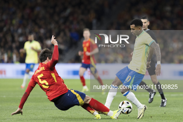 Rodrygo Goes of Brazil and Robin Le Normand of Spain are fighting for the ball during the friendly match between Spain and Brazil at Santiag...
