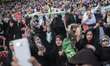 Veiled Iranian women are holding up their hands as a sign of unity with Iran's Supreme Lea...