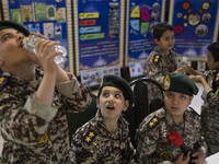 Young Iranian schoolboys in military uniforms are standing together in the Imam Khomeini Grand Mosque at the 31st edition of the Internation...
