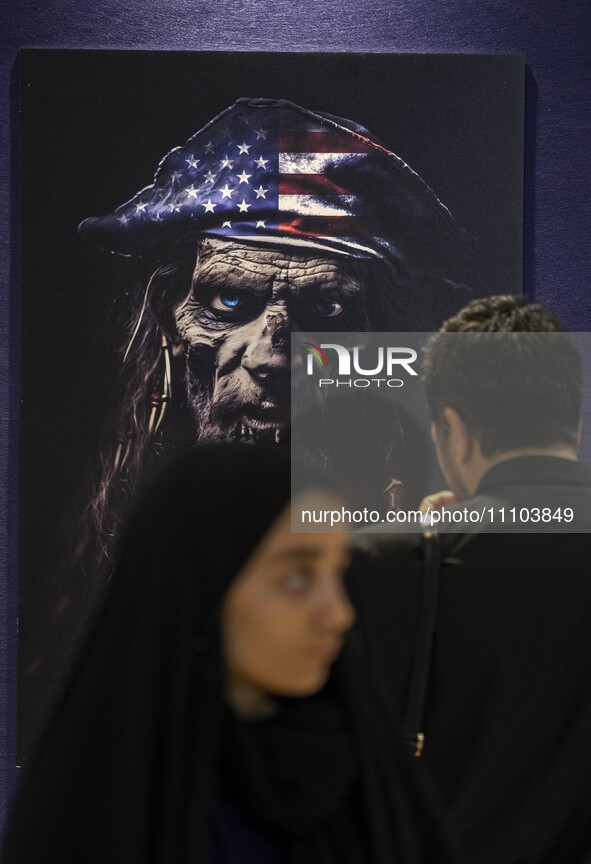 An Iranian man is looking at an anti-U.S. poster in the Imam Khomeini Grand Mosque at the 31st edition of the International Holy Quran Exhib...