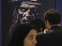 An Iranian man is looking at an anti-U.S. poster in the Imam Khomeini Grand Mosque at the 31st edition of the International Holy Quran Exhib...