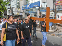 People are carrying a large cross during a rally organized to observe Good Friday in Kolkata, India, on March 29, 2024. (