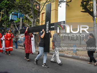 People are carrying a large cross during a rally organized to observe Good Friday in Kolkata, India, on March 29, 2024. (
