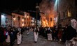 People wearing white hooded costumes and bringing Jesus Christ cross are seen next to a gi...