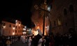 People wearing white hooded costumes and bringing Jesus Christ cross are seen next to a gi...