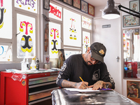 In Mexico City, Mexico, on March 28, 2024, tattoo artist Israel Ortega, also known as Mr. Kaliman, is preparing a design before tattooing a...