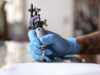 In Mexico City, Mexico, on March 28, 2024, tattoo artist Israel Ortega, also known as Mr. Kaliman, is using a tattoo machine at a salon in t...