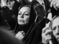(EDITOR'S NOTE: Image was converted to black and white) One of the women in the procession is lowering the veil over her face during the pro...