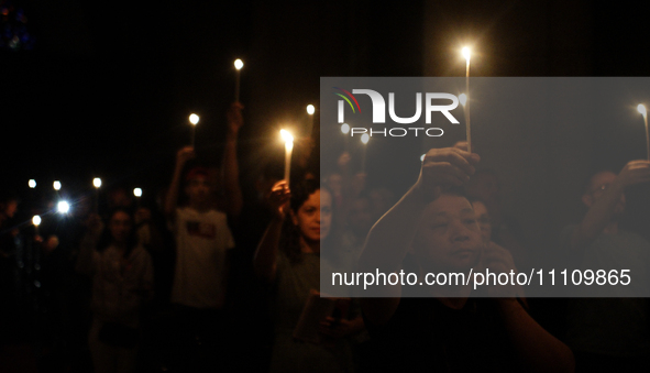 Members of the clergy and believers are attending the Easter Vigil Mass and holding candles at the Cathedral of Se in Sao Paulo, Brazil, on...