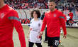 Uros Duranovic of Hamrun Spartans is entering the pitch holding hands with a young mascot...