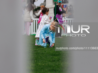 Seen past a fence, a child participates in the 2024 White House Easter Egg Roll on the South Lawn of the White House in Washington, D.C. on...
